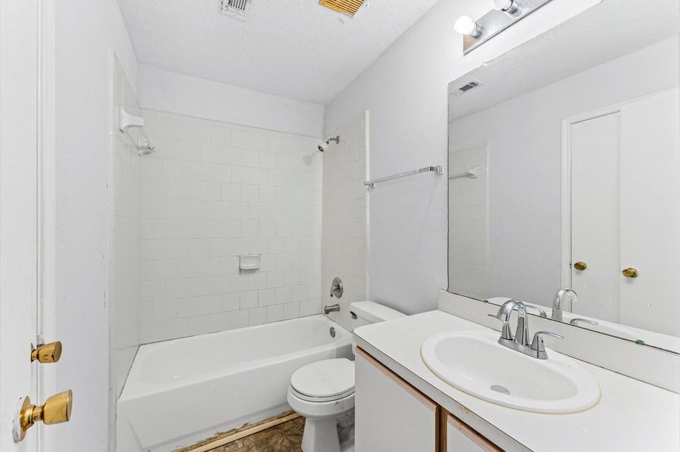 Baño antes de la remodelación, con bañera y lavabo.