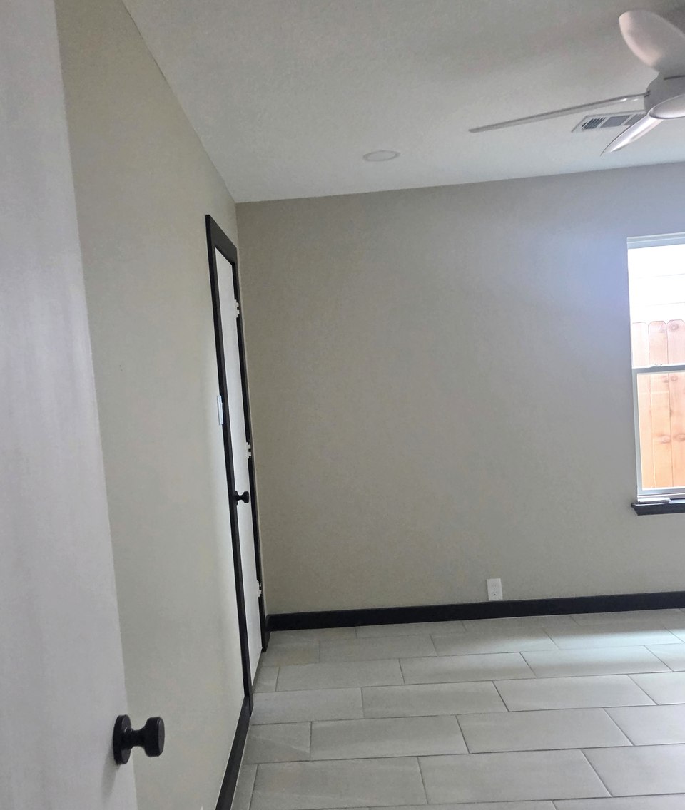 Dormitorio con paredes pintadas y piso de azulejo.